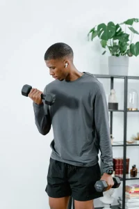 african american man working out with dumbells and listening to music